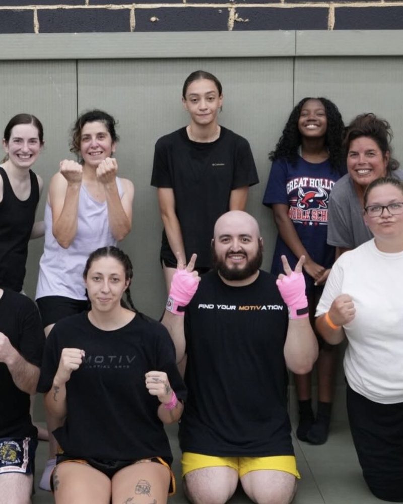 A cardio kickboxing class posing together after training